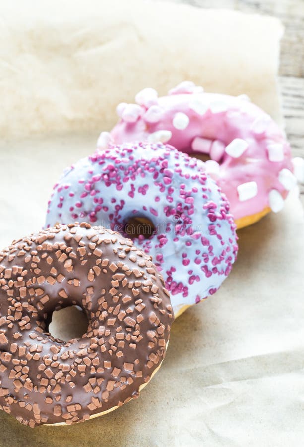 Colourful donuts on the baking paper. Heap, junk.