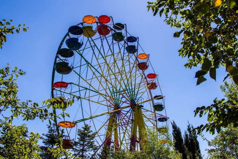 Colourful ferris wheel, front view, daytime, park, clear sky, beautiful weather