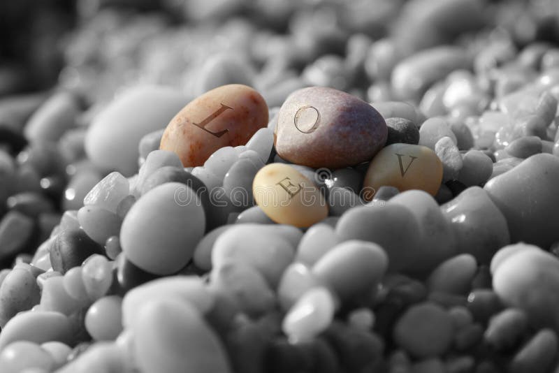 Some smooth stones engraved with the words love in gray stones. Some smooth stones engraved with the words love in gray stones