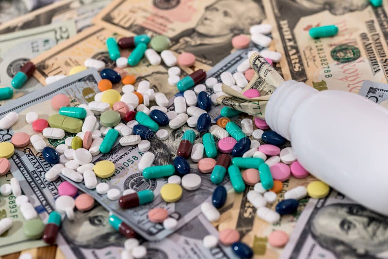 Colourful pills on dollar banknotes with container royalty free stock photo Colourful pills on dollar banknotes with container royalty free stock photo