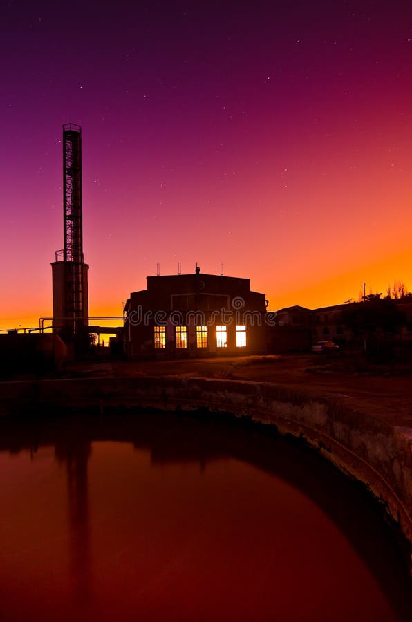 Colourful sunset behind an industrial building