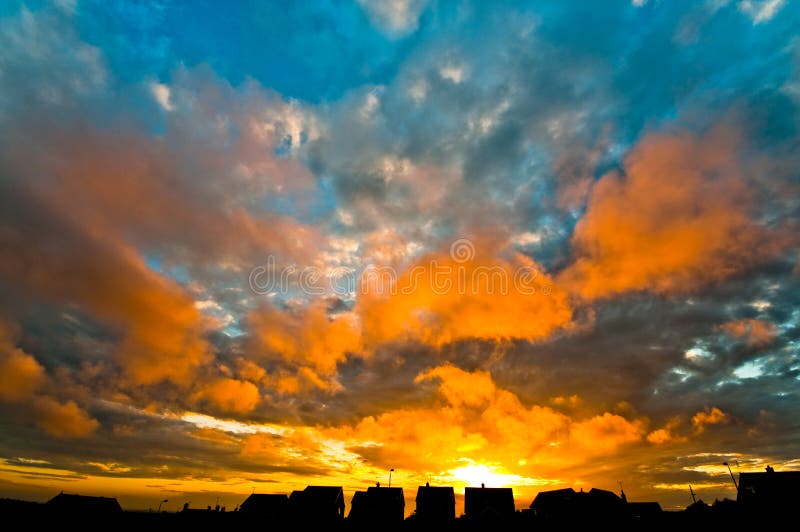 Colourful sunset with houses and field