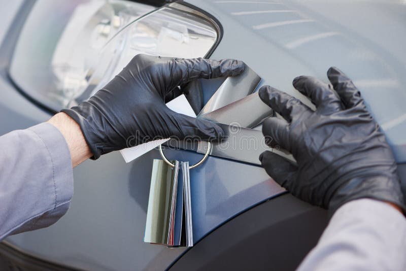 Colourist man selecting color of car with paint matching samples royalty free stock photography Colourist man selecting color of car with paint matching samples royalty free stock photography