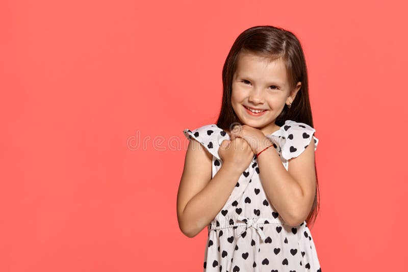 Colpo dello studio del primo piano di bella bambina castana che posa contro un fondo rosa fotografie stock Colpo dello studio del primo piano di bella bambina castana che posa contro un fondo rosa fotografie stock