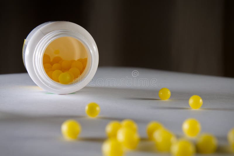 Colpo molle del fuoco di piccole pillole gialle della palla con attenzione all'interno della bottiglia fotografia stock libera da diritti Colpo molle del fuoco di piccole pillole gialle della palla con attenzione all'interno della bottiglia fotografia stock libera da diritti