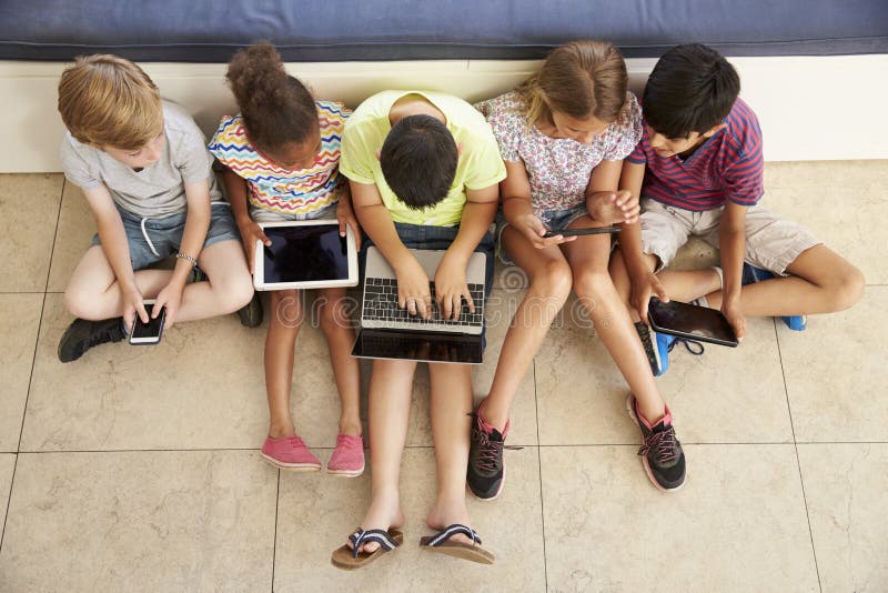 Overhead Shot Of Children Sitting On Floor Using Technology. Overhead Shot Of Children Sitting On Floor Using Technology