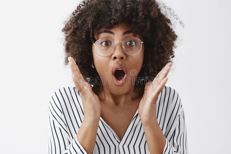 Colpo in testa della femmina afroamericana attraente impressionata con l'acconciatura di afro nell'apertura boccheggiante di vetr immagine stock Colpo in testa della femmina afroamericana attraente impressionata con l'acconciatura di afro nell'apertura boccheggiante di vetr immagine stock