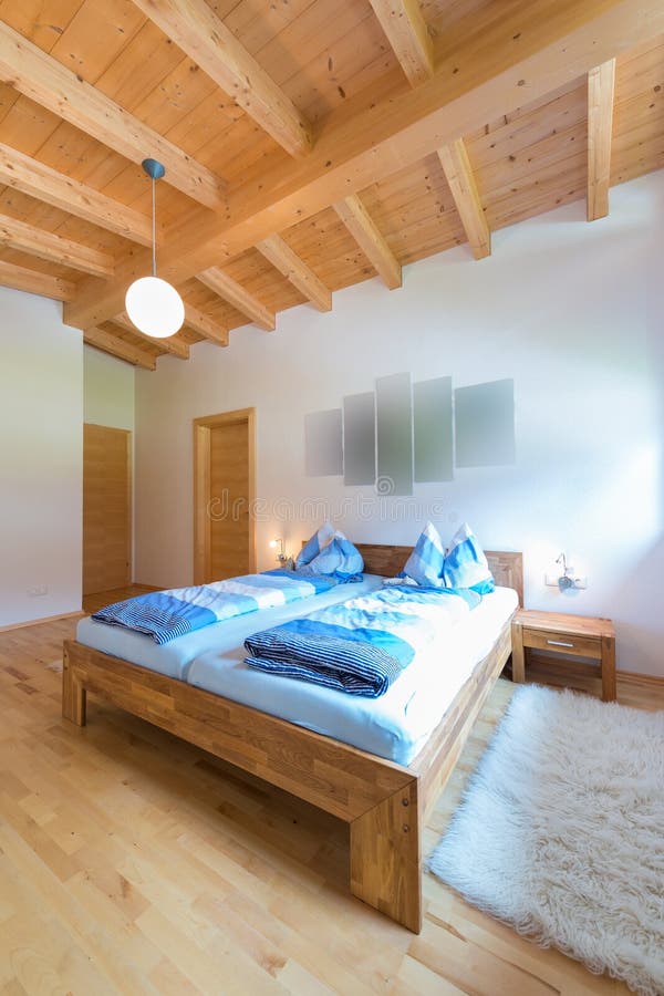Colpo verticale del letto di legno in camera da letto immagine stock libera da diritti