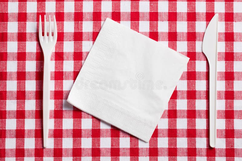 Coltelleria di plastica sulla tovaglia checkered fotografia stock libera da diritti Coltelleria di plastica sulla tovaglia checkered fotografia stock libera da diritti