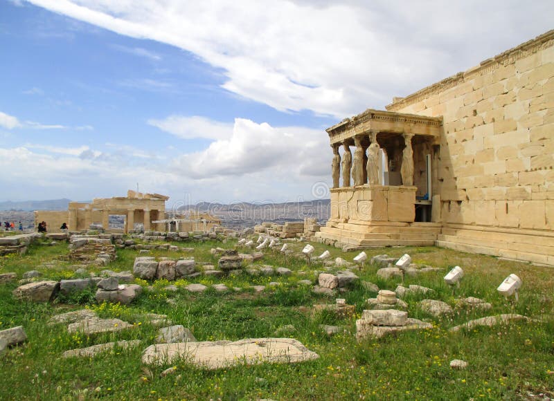 Caryatid Columns of the Porch of Erechtheion Ancient Greek Temple with Propylaea Monumental Gate in the Distance, Acropolis of Athens, Greece, Texture Background antique archaeology architecture awesome blue building city cloud culture erechtheum europe famous grass green heritage hilltop historic history impressive incredible landmark marble old outdoors people ruin sanctuary sculpture sightseeing site sky statue stone structure stunning tourism travel unesco vacation visitor white world. Caryatid Columns of the Porch of Erechtheion Ancient Greek Temple with Propylaea Monumental Gate in the Distance, Acropolis of Athens, Greece, Texture Background antique archaeology architecture awesome blue building city cloud culture erechtheum europe famous grass green heritage hilltop historic history impressive incredible landmark marble old outdoors people ruin sanctuary sculpture sightseeing site sky statue stone structure stunning tourism travel unesco vacation visitor white world