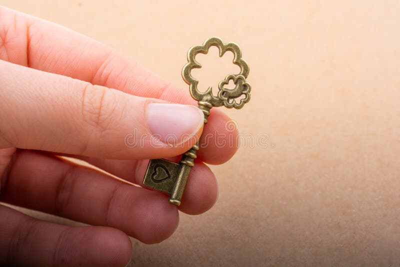Mão segurando uma chave decorativa de estilo retrô imagem de stock