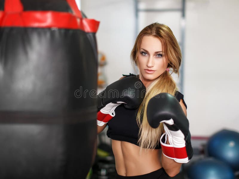 Mujer atractiva con guantes de boxeo listos para hacer ejercicio