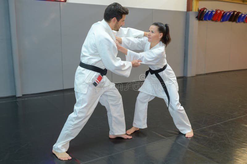 Combatientes del judo de la mujer y del hombre en pasillo de deporte imagen de archivo Combatientes del judo de la mujer y del hombre en pasillo de deporte imagen de archivo