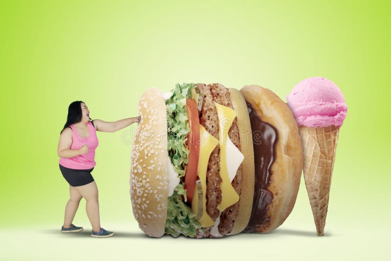 Combattimento di peso eccessivo della donna con gli alimenti non sani immagine stock Combattimento di peso eccessivo della donna con gli alimenti non sani immagine stock