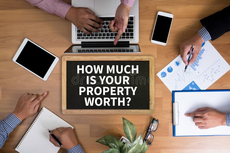 HOW MUCH IS YOUR PROPERTY WORTH? Business team hands at work with financial reports and a laptop, top view. HOW MUCH IS YOUR PROPERTY WORTH? Business team hands at work with financial reports and a laptop, top view