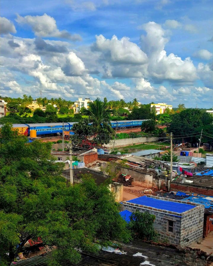 Train passing beside a village with beautiful scenery. Village and city with trees and cloudy sky. Train passing beside a village with beautiful scenery. Village and city with trees and cloudy sky.