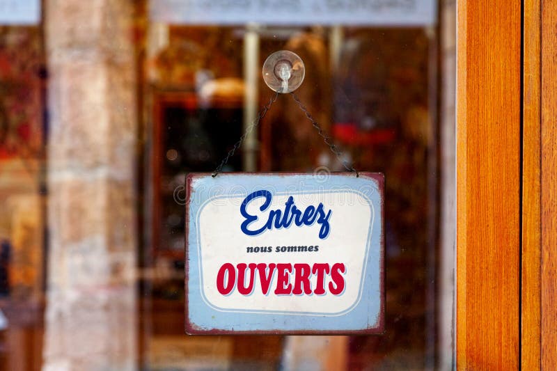 Red and blue sign in the window of a shop saying in French Ouvert, meaning  in English Open Stock Photo - Alamy