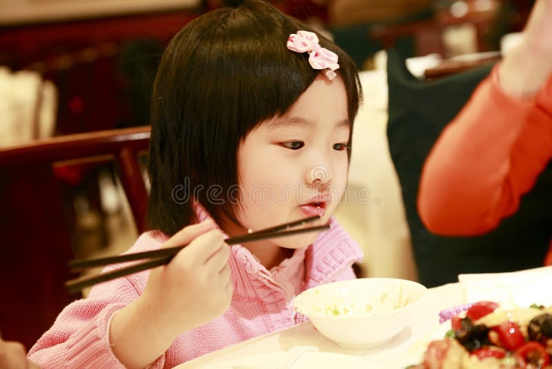 Comer asiático pequeno da menina