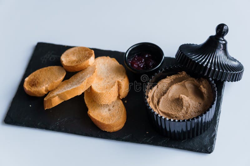 Comerse con salsa y curutones en una pizarra negra imagen de archivo