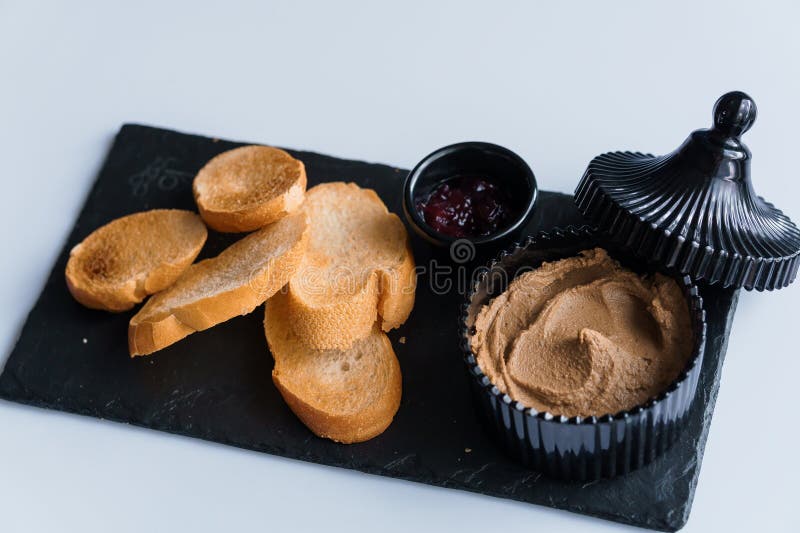 Comerse con salsa y curutones en una pizarra negra fotografía de archivo