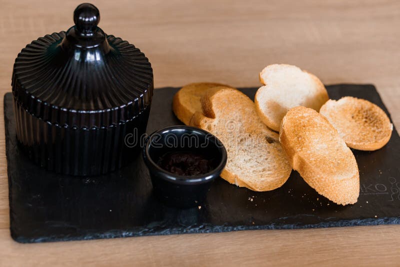 Comerse con salsa y curutones en una pizarra negra imagen de archivo libre de regalías