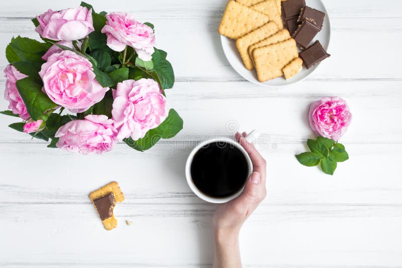 Comfortabele samenstelling met kop koffie, snoepjes en rozen tegen witte uitstekende houten lijst Vlak leg, hoogste mening stock afbeeldingen Comfortabele samenstelling met kop koffie, snoepjes en rozen tegen witte uitstekende houten lijst Vlak leg, hoogste mening stock afbeeldingen