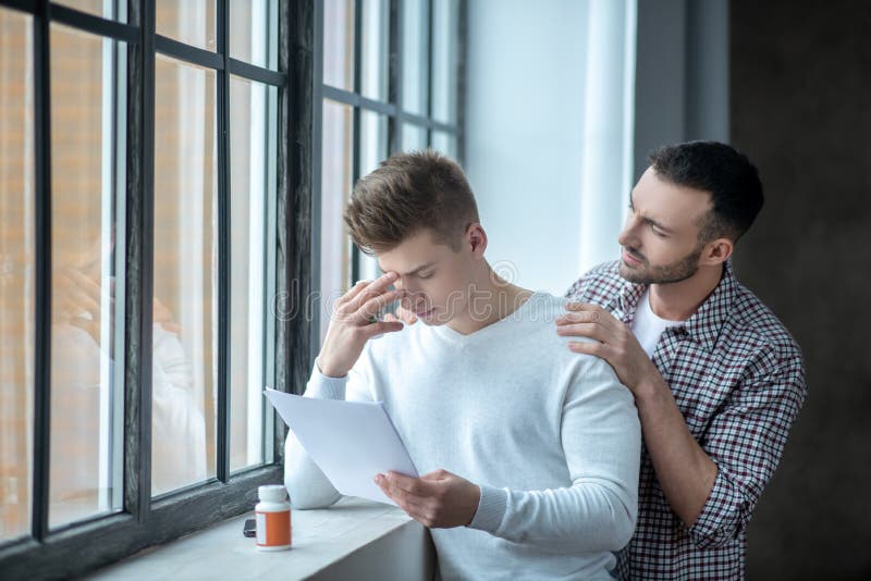 Comforting friend. Dark-haired bearded men trying to comfort his upset partner. Comforting friend. Dark-haired bearded men trying to comfort his upset partner