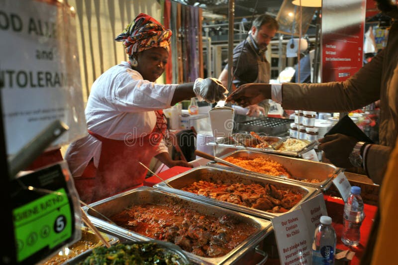 Comida africana en Londres del este en el mercado de Spitalfields imagenes de archivo Comida africana en Londres del este en el mercado de Spitalfields imagenes de archivo
