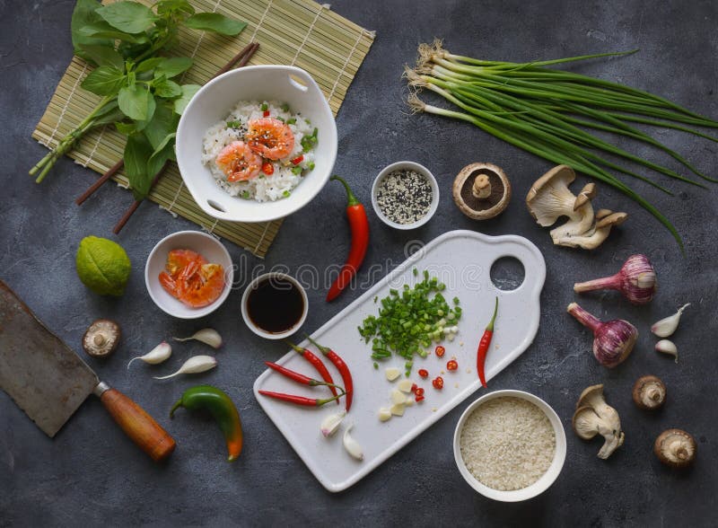 Comida asiática en un fondo oscuro, arroz del wok con los camarones y setas, durante la preparación fotos de archivo Comida asiática en un fondo oscuro, arroz del wok con los camarones y setas, durante la preparación fotos de archivo