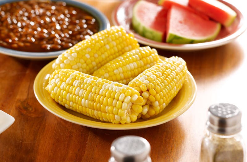 Comida con el maíz en la mazorca en una placa