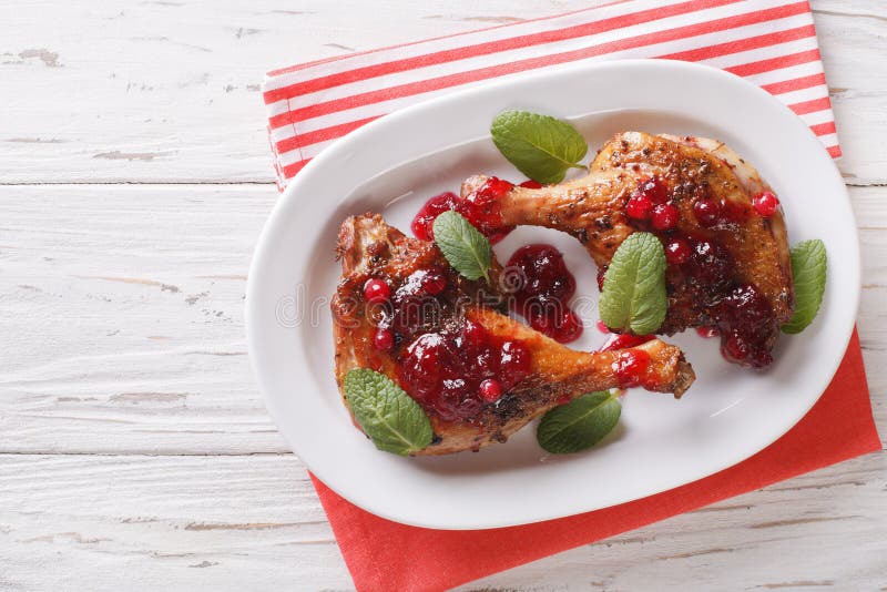 Christmas food: baked duck leg with cranberry sauce and mint closeup on a plate. horizontal view from above. Christmas food: baked duck leg with cranberry sauce and mint closeup on a plate. horizontal view from above