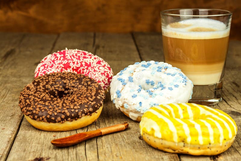 Comida malsana Anillos de espuma en una tabla de madera Café al postre Peligros de la obesidad y de la diabetes Ventas de dulces foto de archivo libre de regalías Comida malsana Anillos de espuma en una tabla de madera Café al postre Peligros de la obesidad y de la diabetes Ventas de dulces foto de archivo libre de regalías