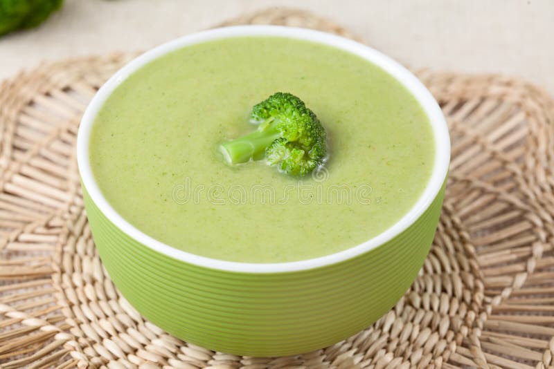 Comida poner crema sana de la sopa del bróculi en un cuenco verde fotografía de archivo Comida poner crema sana de la sopa del bróculi en un cuenco verde fotografía de archivo