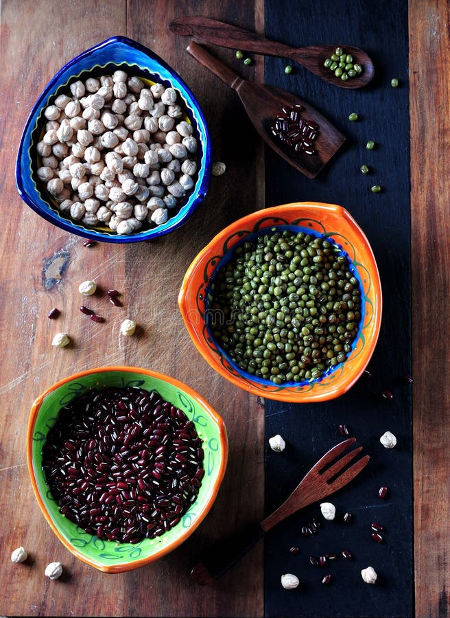 Comida sana - garbanzos, habas rojas, guisantes verdes en viejo fondo de madera imagen de archivo Comida sana - garbanzos, habas rojas, guisantes verdes en viejo fondo de madera imagen de archivo