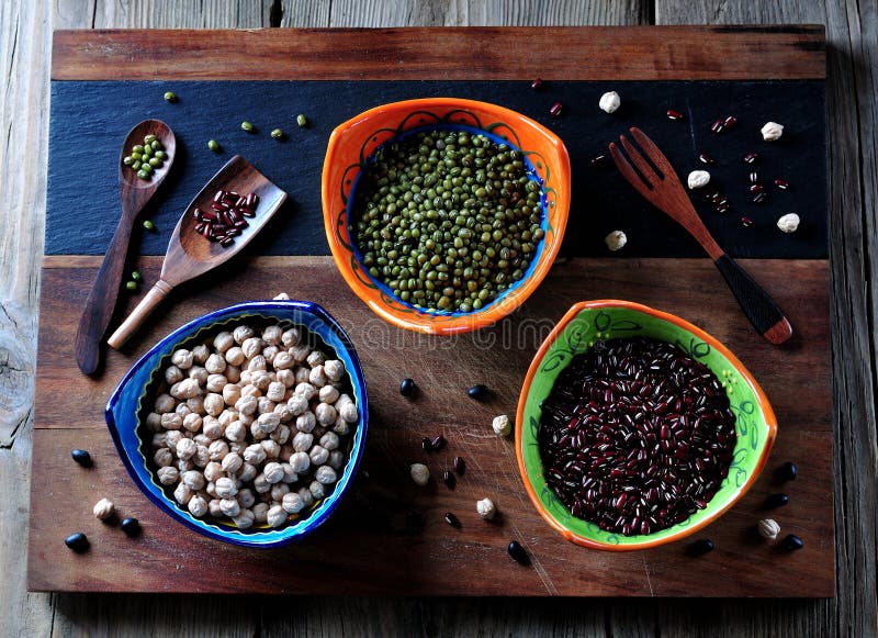 Comida sana - garbanzos, habas rojas, guisantes verdes en viejo fondo de madera imágenes de archivo libres de regalías Comida sana - garbanzos, habas rojas, guisantes verdes en viejo fondo de madera imágenes de archivo libres de regalías