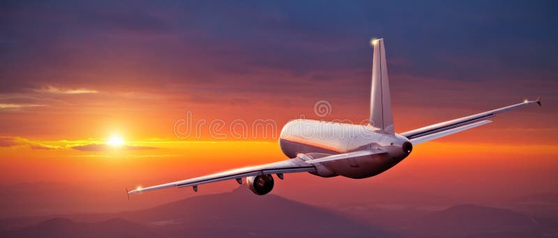 Commercial airplane flying above mountains in sunset