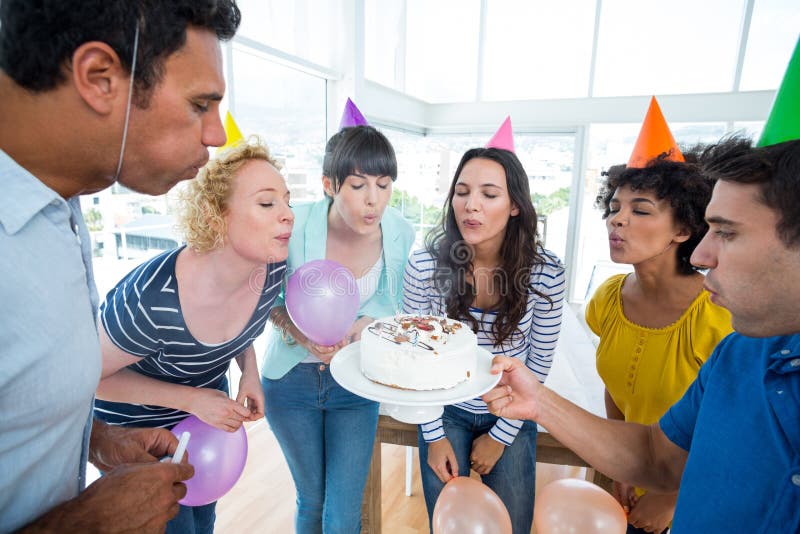 Commerciële team blazende kaarsen op een verjaardagscake stock afbeelding Commerciële team blazende kaarsen op een verjaardagscake stock afbeelding