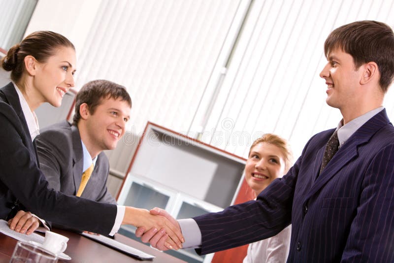 Businessman and woman shaking hands at meeting in the office. Businessman and woman shaking hands at meeting in the office