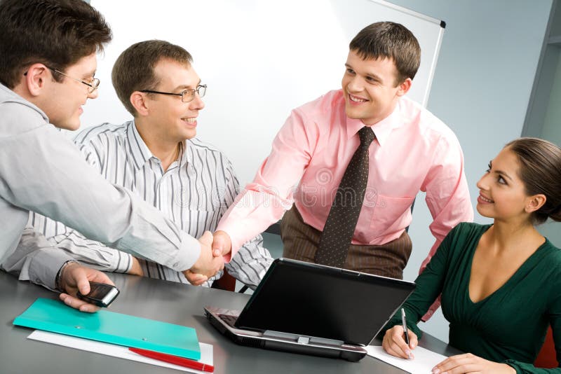 Portrait of confident people shaking hands at business meeting. Portrait of confident people shaking hands at business meeting