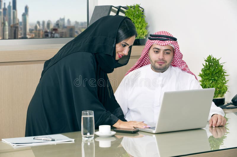 Commerciële Vergadering in bureau, Arabische zakenman & Arabische Secretaresse die hijab het werken aan laptop dragen royalty-vrije stock foto's Commerciële Vergadering in bureau, Arabische zakenman & Arabische Secretaresse die hijab het werken aan laptop dragen royalty-vrije stock foto's