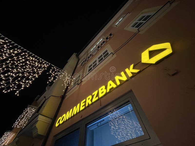 Sign on a german Commerzbank bank during night time with christmas decorations - copy space in the upper left. Sign on a german Commerzbank bank during night time with christmas decorations - copy space in the upper left