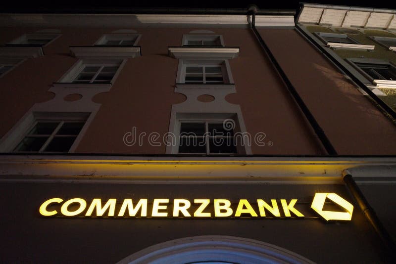 Sign on a german Commerzbank bank during night time - focus on the sign, copy space above. Sign on a german Commerzbank bank during night time - focus on the sign, copy space above