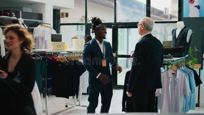 Commis au détail suggérant une cravate pour faire correspondre une chemise noire pour l'usure formelle