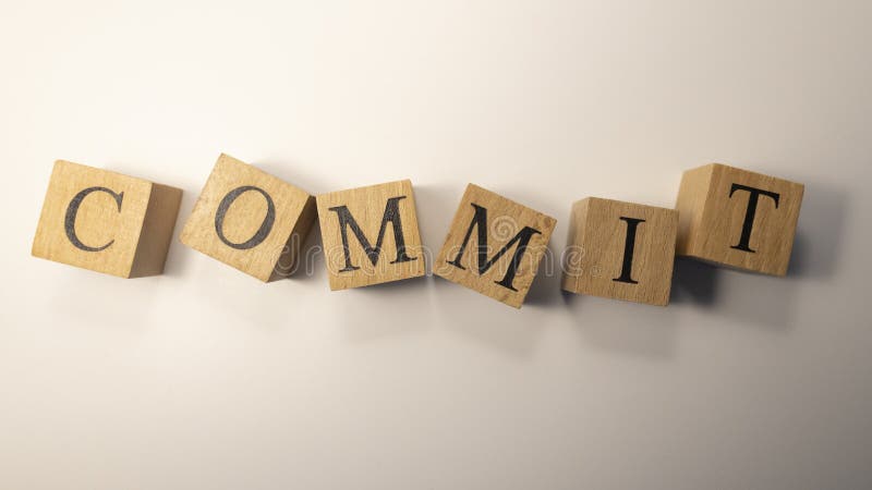 “Commit”这个词是由木块组成的。特写。 库存照片