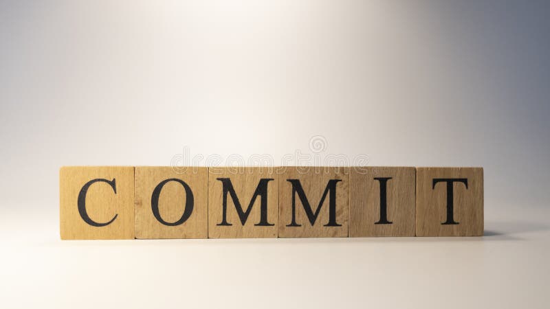 “Commit”这个词是由木块组成的。特写。 库存照片