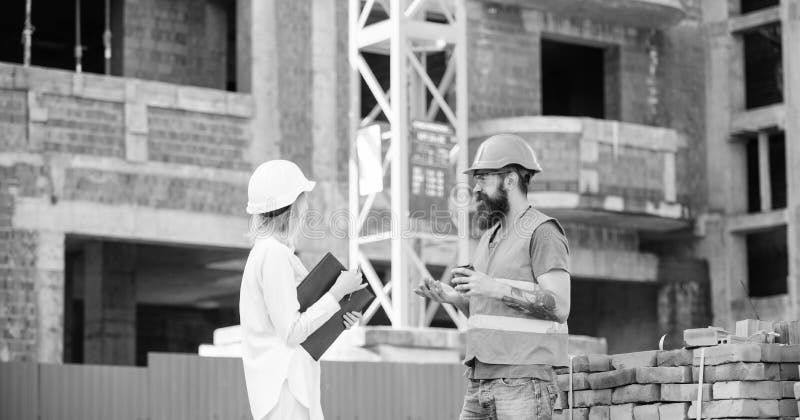 Communicatie van het bouwteam concept De vrouweningenieur en de brutale bouwer delen bouwwerfachtergrond mee royalty-vrije stock afbeelding Communicatie van het bouwteam concept De vrouweningenieur en de brutale bouwer delen bouwwerfachtergrond mee royalty-vrije stock afbeelding
