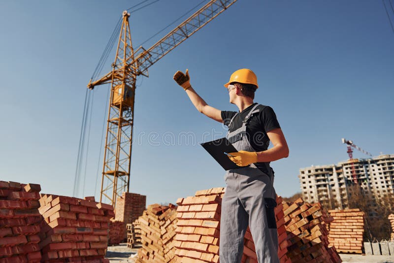 Communicating with Crane Guy. Construction Worker in Uniform and Safety