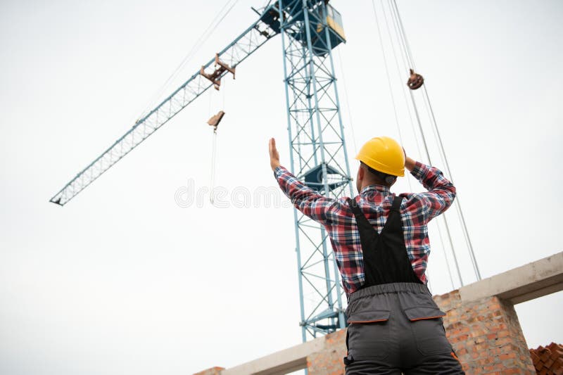 Communicating with Crane Guy. Construction Worker in Uniform and Safety