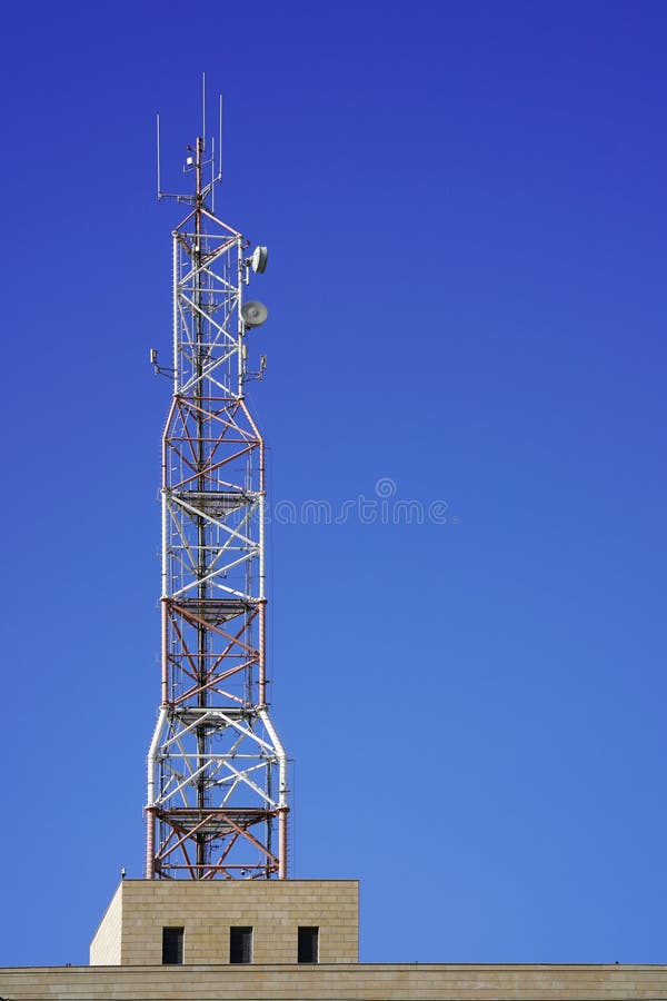 Communication tower network with blue sky.Telecommunication mast television antennas. Technology on the top of the telecommunication GSM 5G,4G,3G tower. Cellular phone antennas on a building roof. Communication tower network with blue sky.Telecommunication mast television antennas. Technology on the top of the telecommunication GSM 5G,4G,3G tower. Cellular phone antennas on a building roof