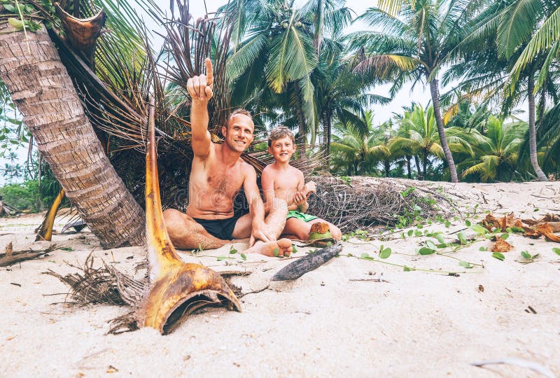Como shipwrecke: el padre y el hijo juegan juntos en la playa tropical imagen de archivo Como shipwrecke: el padre y el hijo juegan juntos en la playa tropical imagen de archivo